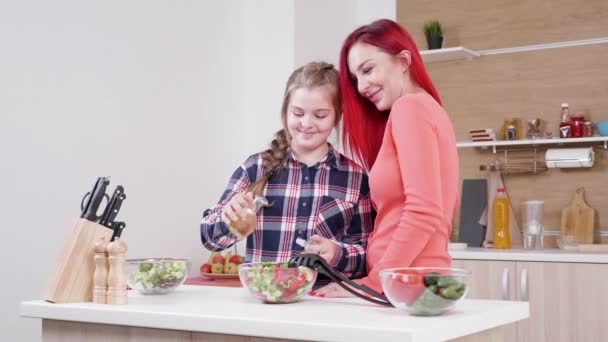 Tochter gießt Öl auf Salat, während ihre Mutter in ihrer Nähe ist — Stockvideo