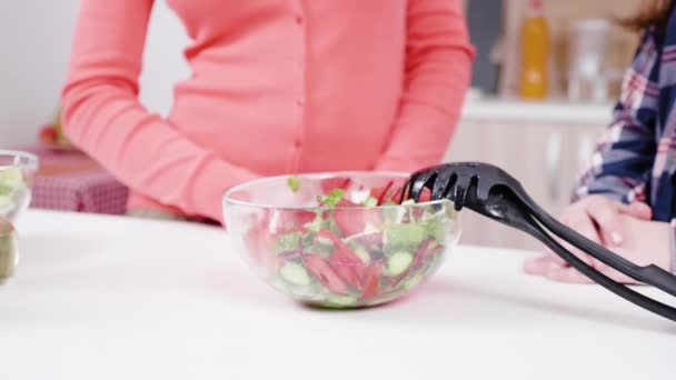 Kvinna som saltning sallad på köket — Stockvideo