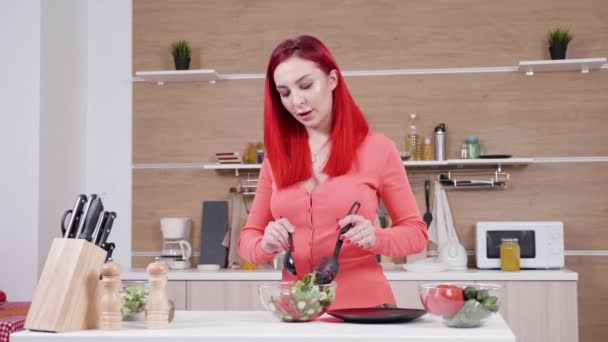 Dochter omarmen van haar moeder, terwijl ze salade in de keuken maakt — Stockvideo