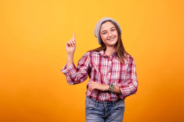 Niña apuntando en estudio sobre fondo amarillo . —  Fotos de Stock