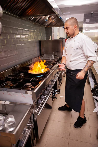 Chef fazendo flambe para prato em panela com grande chama de fogo — Fotografia de Stock