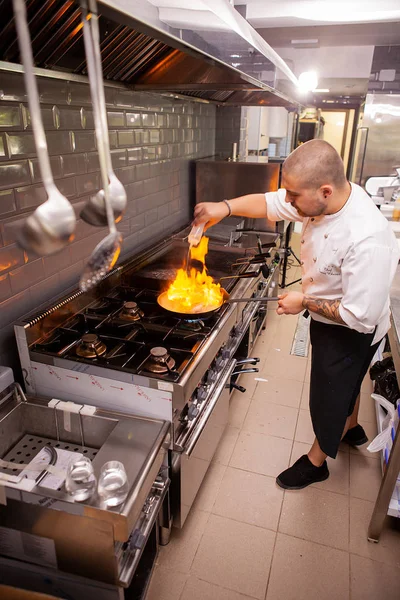 Chef fazendo flambe para prato em panela com grande chama de fogo — Fotografia de Stock