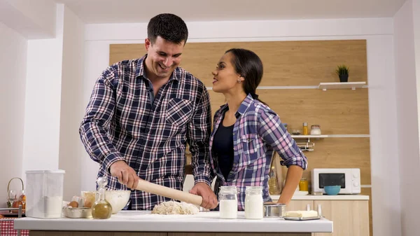 Junge Frau gibt ihrem Mann beim Kochen Zuneigung — Stockfoto