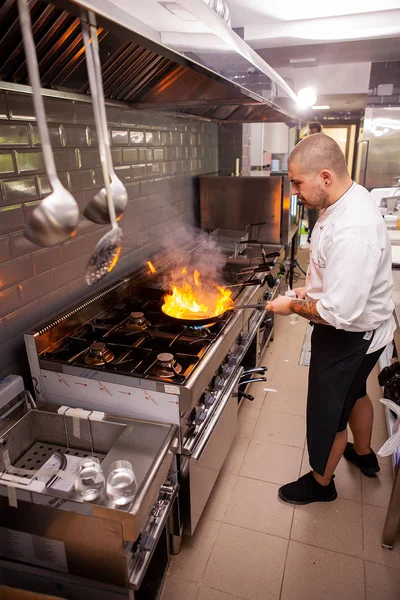Chef cozinhar e fazer flambe em alimentos na cozinha do restaurante — Fotografia de Stock