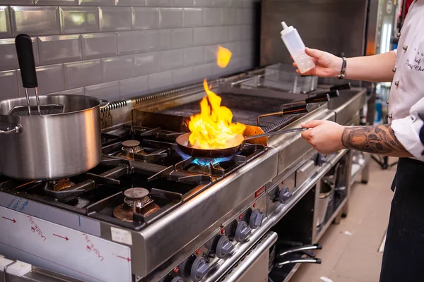 Chef fazendo carne flambe na panela — Fotografia de Stock