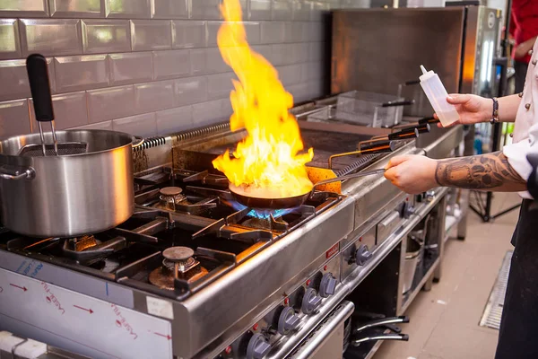 Chef fazendo carne flambe na panela — Fotografia de Stock