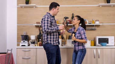 Genç çift mutfak araçları ile oynarken, akşam yemeği hazır hale getirilir