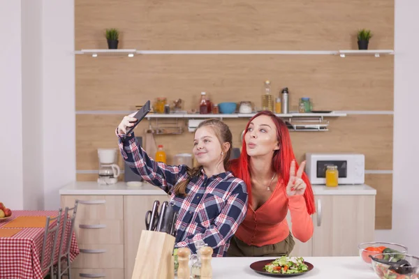 Mutter und Tochter kochen und machen Fotos beim Lächeln — Stockfoto