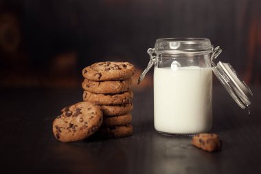 A yığın-in karanlık eski ahşap masa üzerinde Sütlü çikolatalı kurabiye