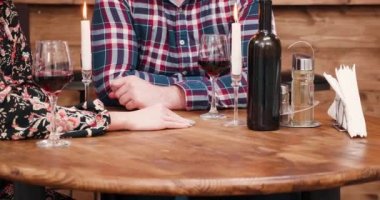 Sevilen bir kişinin elini alarak. Görüntüleri vintage restoranda kapatın. Tablo ve yanan mum şarap şişe