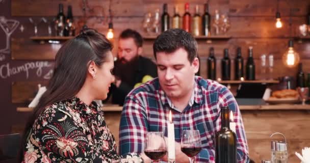 Zoom in colpo di bella coppia caucasica clinking loro bicchieri con il vino — Video Stock