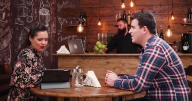 Güzel çift dijital tablet şık pub, Restoran veya kahve dükkanı menüsünden seçim. Garson onlara geliyor ve Not alır.