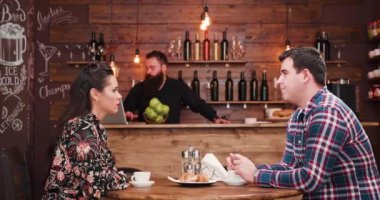 Bearded waiter checks on his clients
