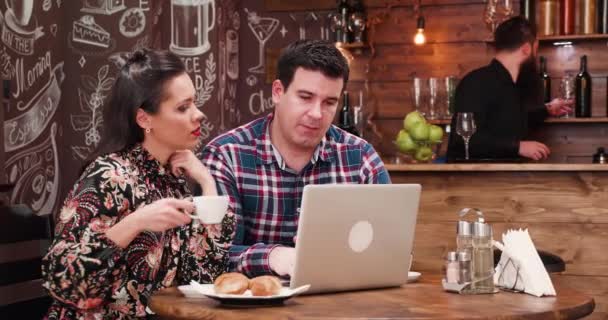 Пара пьет кофе и смотрит на экран компьютера — стоковое видео