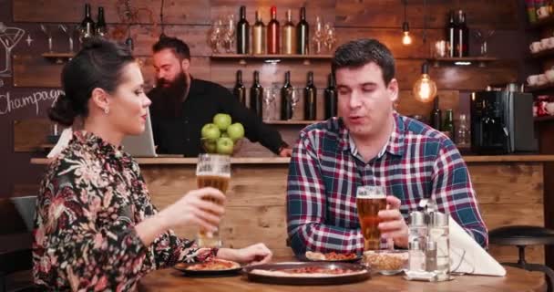 Pizza essen und Bier trinken in einem rustikalen Pub oder Restaurant — Stockvideo