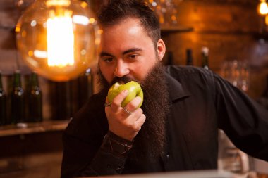 Vintage barda bir yeşil elma yeme Bearderd barmen