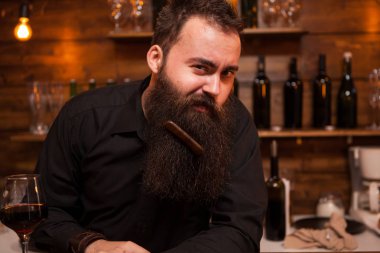 Yakışıklı genç barmen sakalını ile oynamak.