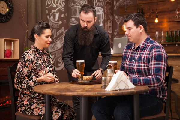 Hipster barman dando a ordem para belo jovem casal . — Fotografia de Stock