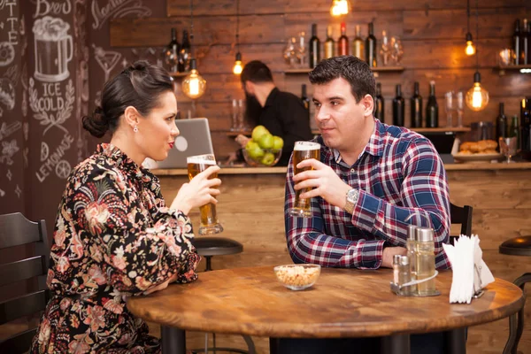 Atractiva pareja bebiendo cerveza en un hermoso pub hipster . — Foto de Stock