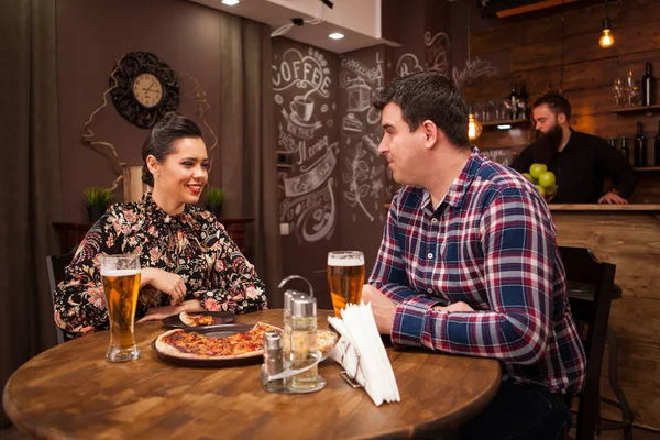 Casal feliz beber cerveja e comer pizza . — Fotografia de Stock