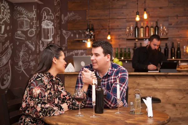 Casal em um encontro sentado em um pub hipster beber vinho tinto . — Fotografia de Stock