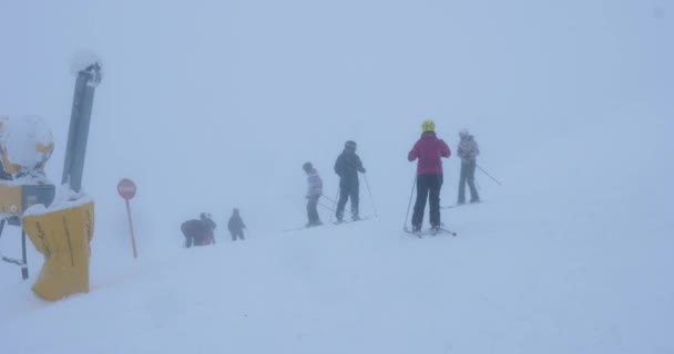 Amateur skiers preparing to ski off the hill — Stock Video