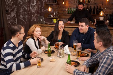 Genç arkadaş togethe bar içinde masa etrafında oturma grubu