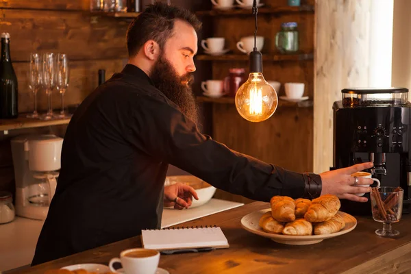 Serveur hipste perlé préparant café derrière le bar . — Photo