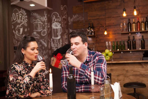 Marido feliz dando a esposa um presente em um pub hipster . — Fotografia de Stock