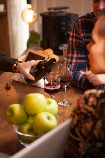 Cantinero vertiendo vino tinto de una botella en una copa de vino . —  Fotos de Stock