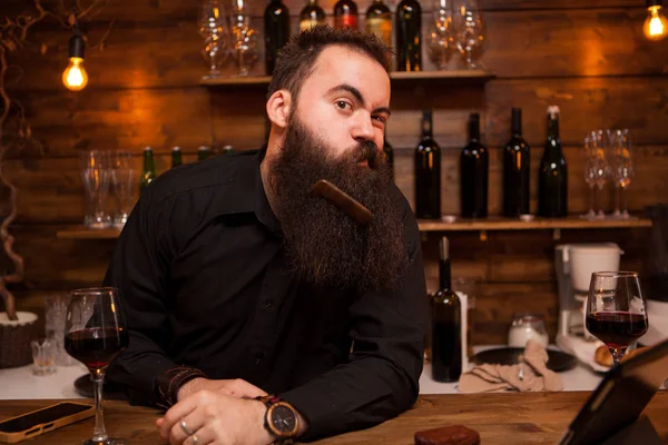 Bonito jovem barman brincando com sua barba . — Fotografia de Stock