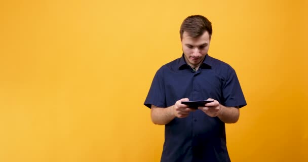 Возбужденный человек играет в видеоигры на мобильном телефоне — стоковое видео
