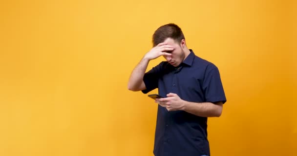 Расстроенный молодой человек с телефоном в руках — стоковое видео