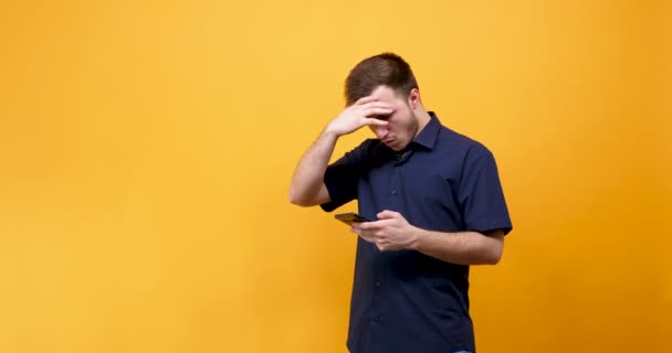 Joven trastornado con un teléfono en las manos — Vídeo de stock