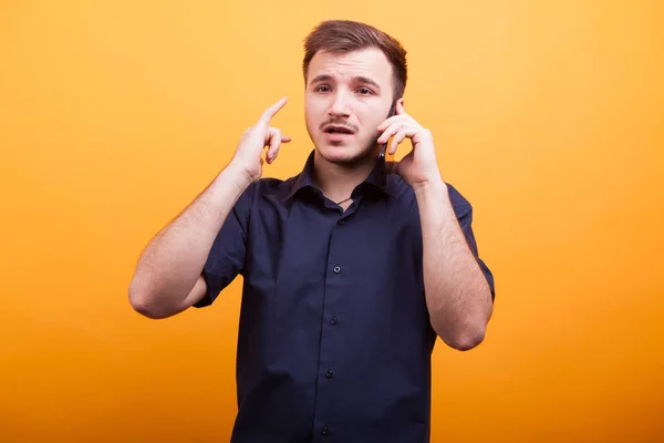 Joven hombre mirando preocupado mientras habla por teléfono —  Fotos de Stock