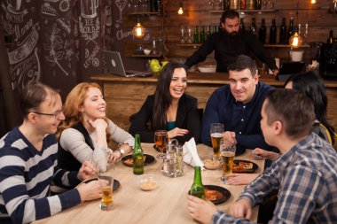 Genç arkadaş togethe bar içinde masa etrafında oturma grubu