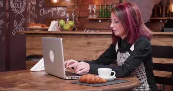 Donna beve caffè mentre digita sulla tastiera del computer portatile — Video Stock