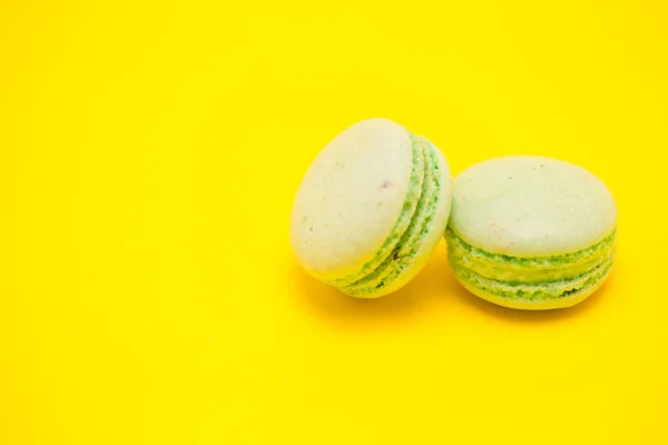 Twee zoete groene bitterkoekjes op gele achtergrond — Stockfoto