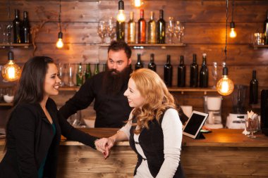 İki genç güzel kadın barda konuşuyor