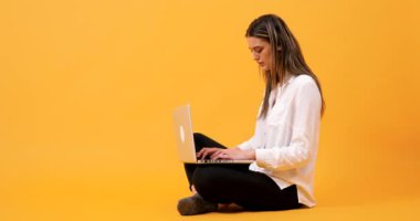 Sarı bir arka plan üzerinde oturan öğrenci