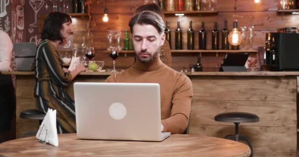 Hipster pekerja lepas yang disajikan kopi saat bekerja di laptop — Stok Video