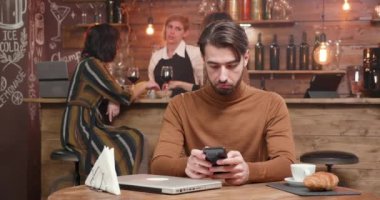 Genç yakışıklı girişimci çalışma remotly sırasında onun smartphone cep telefonu ile mesaj yazarken