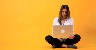 Genç kadın türleri oturarak laptop