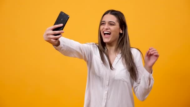 Χαμογελαστό γυναίκα δείχνει ένα σημάδι της ειρήνης και λαμβάνοντας μια selfie — Αρχείο Βίντεο