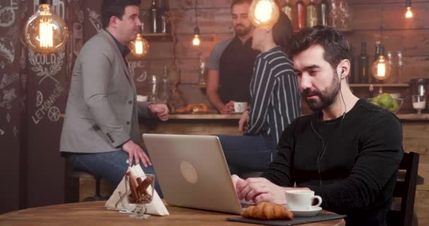 Junger Mann bejubelt eine Leistung, während er in einem Coffeeshop freiberuflich arbeitet — Stockvideo