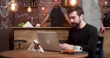 Müşteri kahve dükkanı girerken sakallı beyaz bir adam onun laptop İnşaat