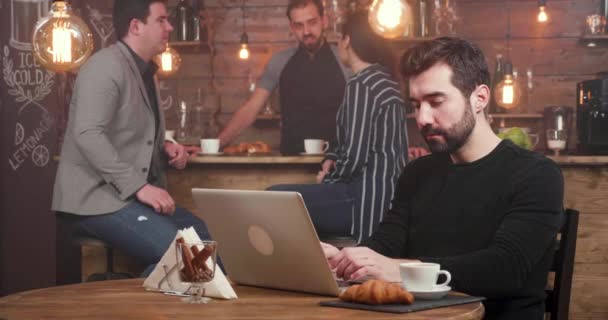 Hombre guapo aletas para escribir en su computadora portátil y deja la mesa — Vídeos de Stock