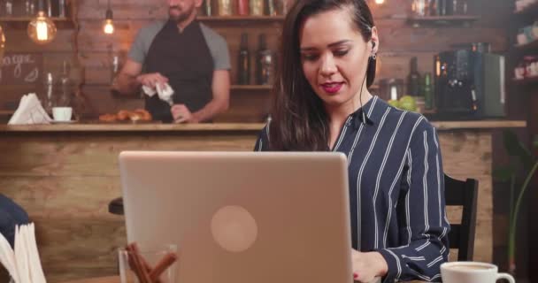 Κοντινό πλάνο του μια γυναίκα συγγραφέας εργάζεται για το φορητό υπολογιστή από ένα κατάστημα καφέ — Αρχείο Βίντεο