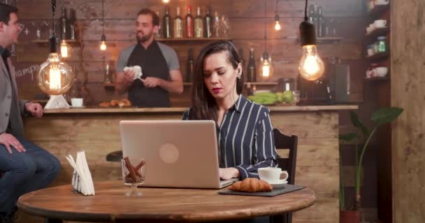 Genç, güzel bir kadın odaklı bir restoranın çalışma onu laptop adlı bir metin yazma — Stok video