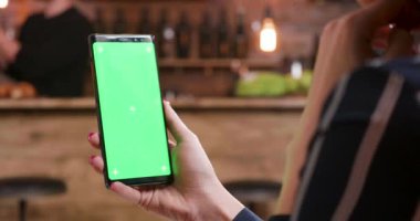 Güzel kadının bir smartphone chroma anahtar ile onun sağ elinde tutan